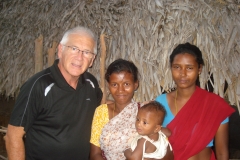 Alan with family in hut INdia